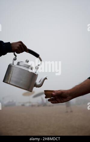 Uomo che versa il famoso chai o tè ad assi Ghat. Varanasi, Uttar Pradesh, India Foto Stock