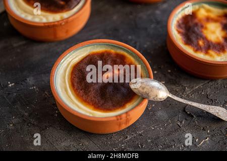 Dessert al budino di riso cotto in una pentola di argilla nel forno. Pronto per essere servito su un tabellone nero Foto Stock