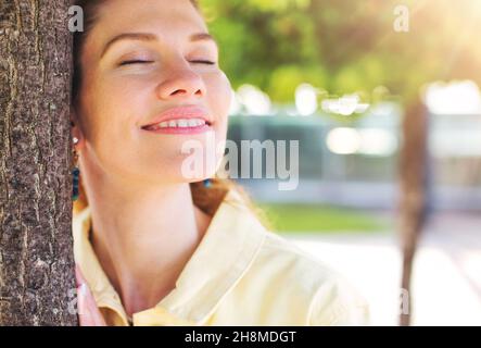 Giovane anni '30 caucasica romantica donna sognare l'amore nel parco al tramonto Foto Stock