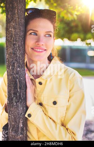 Felice giovane caucasica romantica donna pensando all'amore in parco a albero, all'aperto Foto Stock