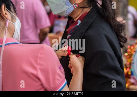 Bangkok, Tailandia. 01 dicembre 2021. Il personale del distretto di Ratchathewi spacca una croce rossa piegata a nastro su una camicia da donna durante le attività della campagna della Giornata Mondiale dell'AIDS 2021 a Bangkok. Le attività della campagna della Giornata Mondiale dell'AIDS 2021 si sono svolte nel distretto di Ratchathewi, a Bangkok, presso il monumento della vittoria per celebrare la Giornata Mondiale dell'AIDS 2021. Il tema della Giornata Mondiale dell'AIDS 2021 dell'Organizzazione Mondiale della Sanità (OMS) è 'porre fine alle disuguaglianze. Eliminare l'AIDS". “con particolare attenzione a raggiungere le persone rimaste indietro e ad evidenziare le crescenti disuguaglianze nell’accesso ai servizi essenziali per l’HIV. Credit: SOPA Images Limited/Alamy Live News Foto Stock