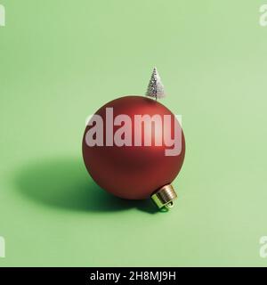 Palla di Natale decorata con un albero di Natale su sfondo verde. Concetto minimo. Quadrato. Foto Stock