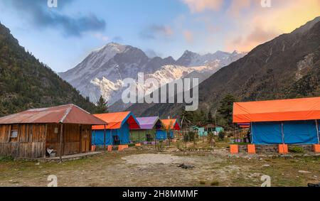 Tende da campeggio per gli amanti dell'avventura e gli escursionisti a Rakchham Himachal Pradesh, India con paesaggio panoramico di montagna Himalaya al tramonto Foto Stock