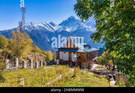 Hotel turistico in legno con vista sulla maestosa catena montuosa Kinnaur Kailash Himalaya a Kalpa, Himachal Pradesh, India Foto Stock