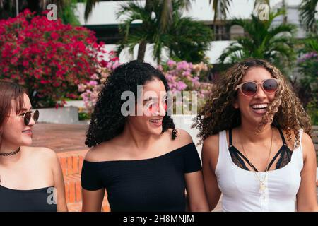 Tre giovani donne che camminano lungo la strada insieme Foto Stock