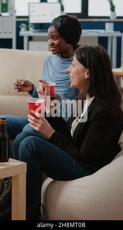 Compagni di lavoro allegri che hanno bevande alcoliche dopo il lavoro in ufficio. I colleghi si godono del tempo libero per un'attività divertente con birra e pizza dopo l'orario di lavoro. Colleghi felici che festeggiano la festa Foto Stock