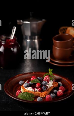 Bruschetta con formaggio, marmellata, lamponi freschi e mirtilli Foto Stock