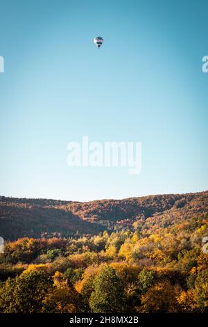 Mongolfiera che vola sopra il paesaggio autunnale. Cielo limpido. Viaggi e avventura in autunno stagione Foto Stock