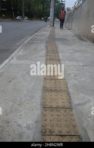 salvador, bahia, brasile - 30 novembre 2021: Vista di un marciapiede con pavimento tattile utilizzato per guidare i ciechi nella città di Salvador. Foto Stock