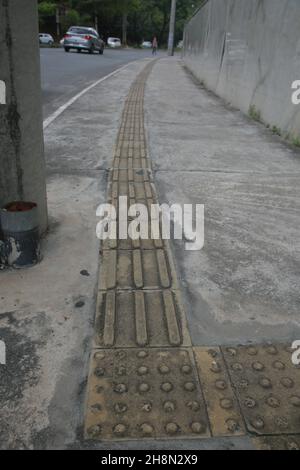 salvador, bahia, brasile - 30 novembre 2021: Vista di un marciapiede con pavimento tattile utilizzato per guidare i ciechi nella città di Salvador. Foto Stock