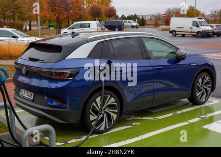 PRAGA, REPUBBLICA CECA - Nov 02, 2021: Un'auto elettrica SUV blu scuro si carica nel parcheggio di un supermercato. Foto Stock