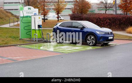 PRAGA, REPUBBLICA CECA - Nov 02, 2021: Un'auto elettrica SUV blu scuro si carica nel parcheggio di un supermercato. Foto Stock