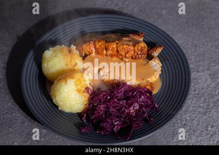 piatto di maiale arrosto con gnocchi e cavolo rosso Foto Stock