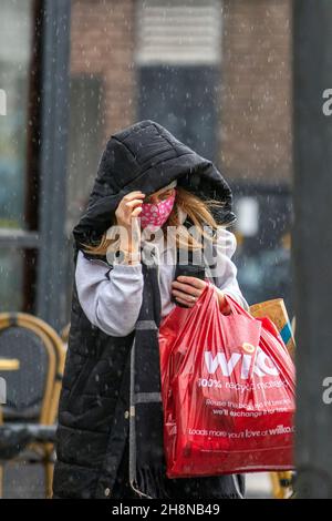 Southport, Lancashire. Meteo UK 01 dic 2021. Negozi di Natale, negozi per lo shopping in una giornata bagnata e ventosa nel centro della città. La pioggia di questa mattina si schiarirà verso sud, ma i venti da freschi a moderati verso nord persisteranno aggiungendo un fattore di raffreddamento considerevole. Credit MediaWorldImages/AlamyLiveNews Foto Stock