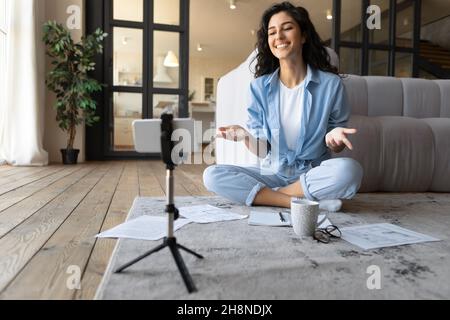 Insegnante femminile millennial che conduce lezione online sulla fotocamera del cellulare, blogger streaming sui social media a casa Foto Stock