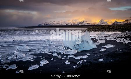 Ice rock con spiaggia di sabbia nera a Jokulsarlon beach (Diamond beach) nel sud-est dell'Islanda Foto Stock