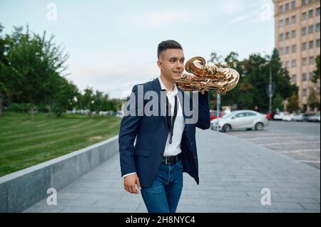 Un sassofonista con sax, edifici sullo sfondo Foto Stock