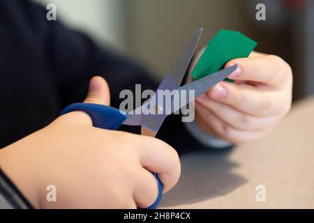 Ragazzo taglia fuori il personaggio con forbici Foto Stock