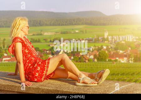 Lifestyle donna turistica in vacanza di viaggio presso le terrazze vigneto. Paesaggio panoramico al tramonto nella città di Hallau del cantone Schaffhausen in Foto Stock