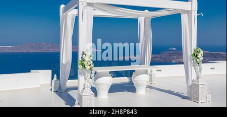 Isola di Santorini, Grecia. Decorazione di nozze in una popolare destinazione di coppia. Elegante arco di nozze con fiori bianchi, vasi sullo sfondo del mare blu Foto Stock