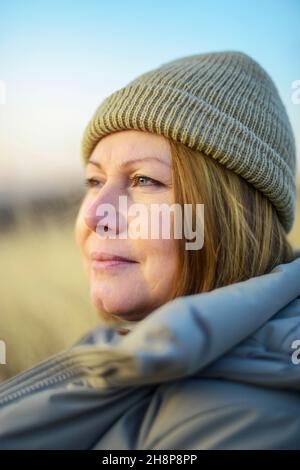 Ritratto di donna adulta in piedi in campo tramonto Foto Stock