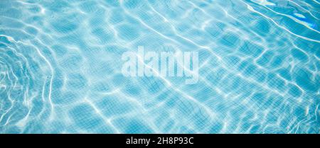 Superficie della piscina blu. Sport d'acqua d'estate, sfondo ricreativo. Consistenza della superficie dell'acqua, blu turchese brillante luminoso giorno closeup. Foto Stock
