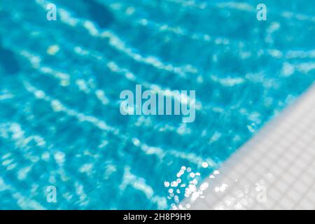 Superficie della piscina blu. Sport d'acqua d'estate, sfondo ricreativo. Consistenza della superficie d'acqua, blu turchese brillante luminoso closeup soleggiato. Rilassati Foto Stock
