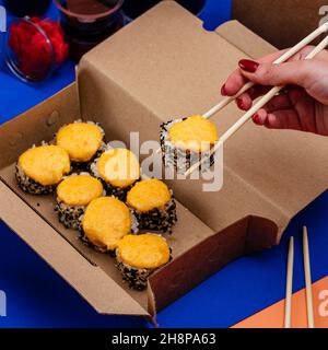 rotoli di sushi in un contenitore monouso Foto Stock