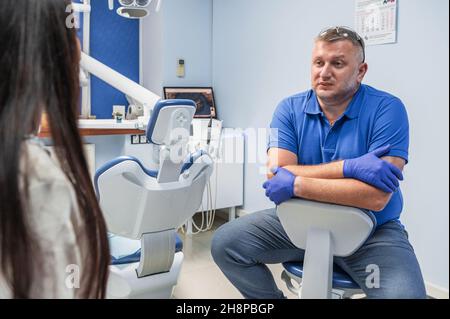 Il dentista consulta un paziente in una clinica dentale Foto Stock