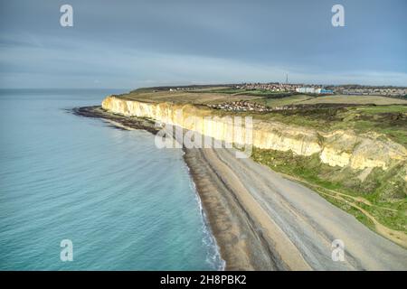 Aereo lungo Newhaven Beach dirigendosi verso le bianche scogliere del Sussex orientale che conducono a Brighton. Foto Stock