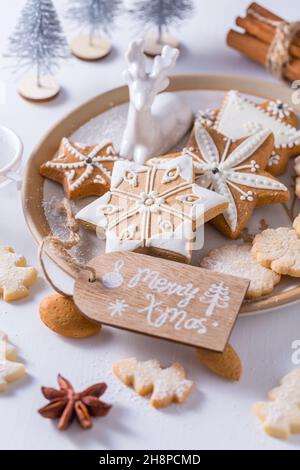 Biscotti di Natale fatti in casa con ornamenti in bianco Foto Stock