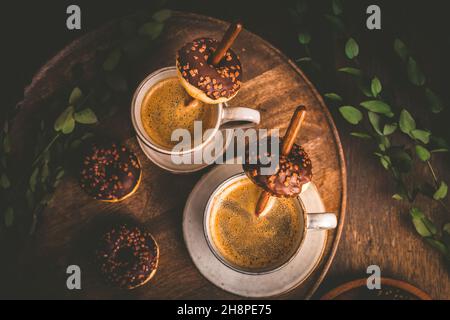 Due tazze di caffe Americano con piccole ciambelle al cioccolato Foto Stock