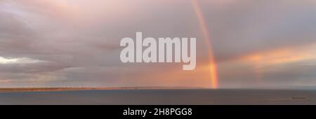 Arcobaleno sul grande fiume Volga grande vista panoramica. Nuvoloso scuro con doppio arcobaleno luminoso e coperto nel cielo Foto Stock