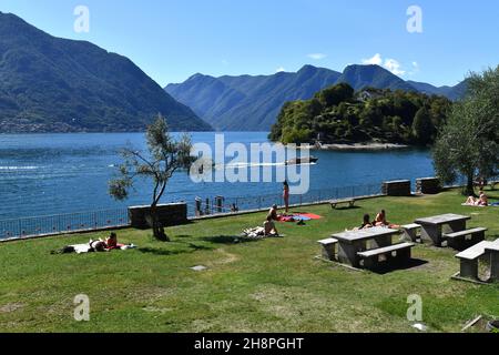 Persone prendere il sole sulla spiaggia pubblica di Ossuccio, Lago di Como, Italia Foto Stock