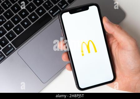McDonalds l'applicazione è aperta nello smartphone. L'uomo sta tenendo un telefono cellulare in mano, l'applicazione aziendale è aperta sullo schermo. Acquisti online sicuri. Novembre 2021, San Francisco, USA Foto Stock