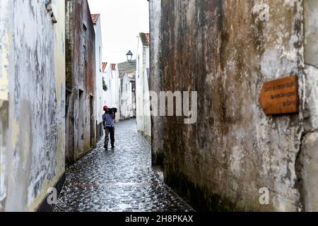 Uomo che trasporta merci per le strade di Vila do Corvo, isola di Corvo Azzorre Portogallo Foto Stock