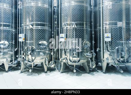 Vasche d'acciaio per la fermentazione di uve in fila. Interni moderni di una cantina Foto Stock