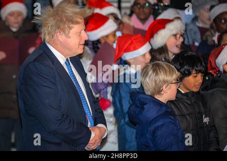 Westminster, Londra, Regno Unito. 01 dicembre 2021. Il primo ministro Boris Johnson accende le luci ufficiali dell'albero di Natale di Downing Street questa sera fuori 10 Downing Street. L'evento vede anche un coro per bambini che canta le carole e gli ospiti invitati a guardare la cerimonia. Credit: Imagplotter/Alamy Live News Foto Stock