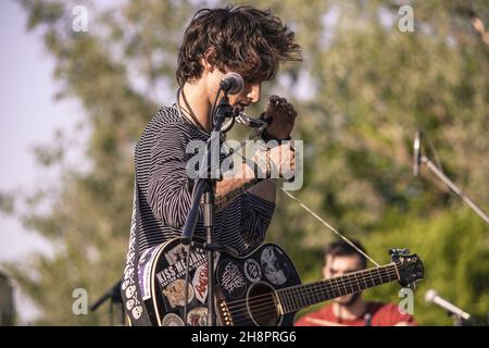 ROVIGO, ITALIA - 12 maggio 2019: Rocker con armonica in un concerto all'aperto al tramonto Foto Stock