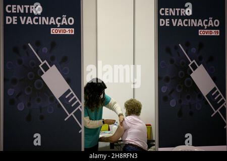 Lisbona, Portogallo. 1 dicembre 2021. Il 1° dicembre 2021 un operatore medico somministra il vaccino COVID-19 ad un ricevente in un nuovo centro di vaccinazione di Lisbona, Portogallo. Credit: Pedro Fiuza/Xinhua/Alamy Live News Foto Stock