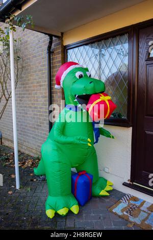 Grande novità verde plastica Blow-up dinosauro festivo fuori di una casa a Surrey nella stagione festiva nel mese di dicembre Foto Stock