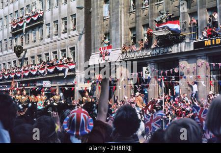 LUGLIO 1981: Le folle che ondeggiavano e si acclamavano alla regina Elisabetta II e al principe Filippo in processione lungo Fleet Street per le nozze del principe Charles e della signora Diana a Londra, Inghilterra Foto Stock