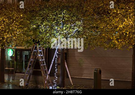 Dublino, Irlanda - 13 novembre 2021: Bella vista serale del processo di decorazione di Natale su o'Connell Street. Lavoratori appesi luce su alberi autunnali Foto Stock