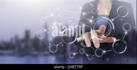 Connessioni di rete innovative e globali, scambi di dati. Mano touch schermo digitale ologramma diagramma circolare segno sulla città luce sfondo sfocato. Foto Stock