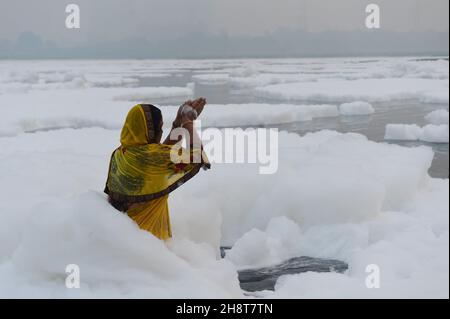 New Delhi, India. 2 dicembre 2021. La schiuma tossica galleggia sulla superficie del fiume Yamuna inquinato, mentre i devoti indù fanno un bagno come parte dei rituali delle celebrazioni di quattro giorni del festival 'Chhath Puja' a Nuova Delhi, India, lunedì 8 novembre 2021. L'antica festa indù dedicata al Dio del sole è celebrata per il benessere, lo sviluppo e la prosperità dei membri della famiglia. Foto di Abhishek/UPI Credit: UPI/Alamy Live News Foto Stock