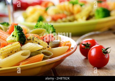 Pasta Penne insalata con broccoli carota di mais e pomodori sul tavolo da cucina Foto Stock