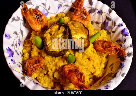 Il cibo migliore del piatto del Bengala è Khichdi, melanzane fritte e gamberi fritti Foto Stock