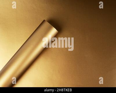 Carta d'oro arrotolata in un tubo, in un cerchio, sfondo astratto per il disegno. Foto Stock