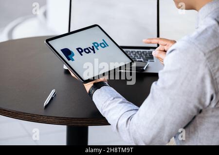 CHIANG mai, THAILANDIA - NOV 28, 2021 : l'uomo tiene l'ipad con le app PayPal sullo schermo. PayPal è un sistema di pagamento elettronico online. Foto Stock