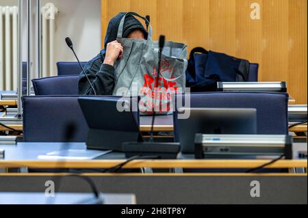02 dicembre 2021, Baviera, Regensburg: L'imputato siede nel tribunale della corte regionale e tiene una borsa davanti al suo volto. La donna di 33 anni è accusata di aver ucciso sua madre. (Al dpa: '61-year-old ucciso con coltello - processo di omicidio contro la figlia comincia') Foto: Armin Weigel/dpa Foto Stock